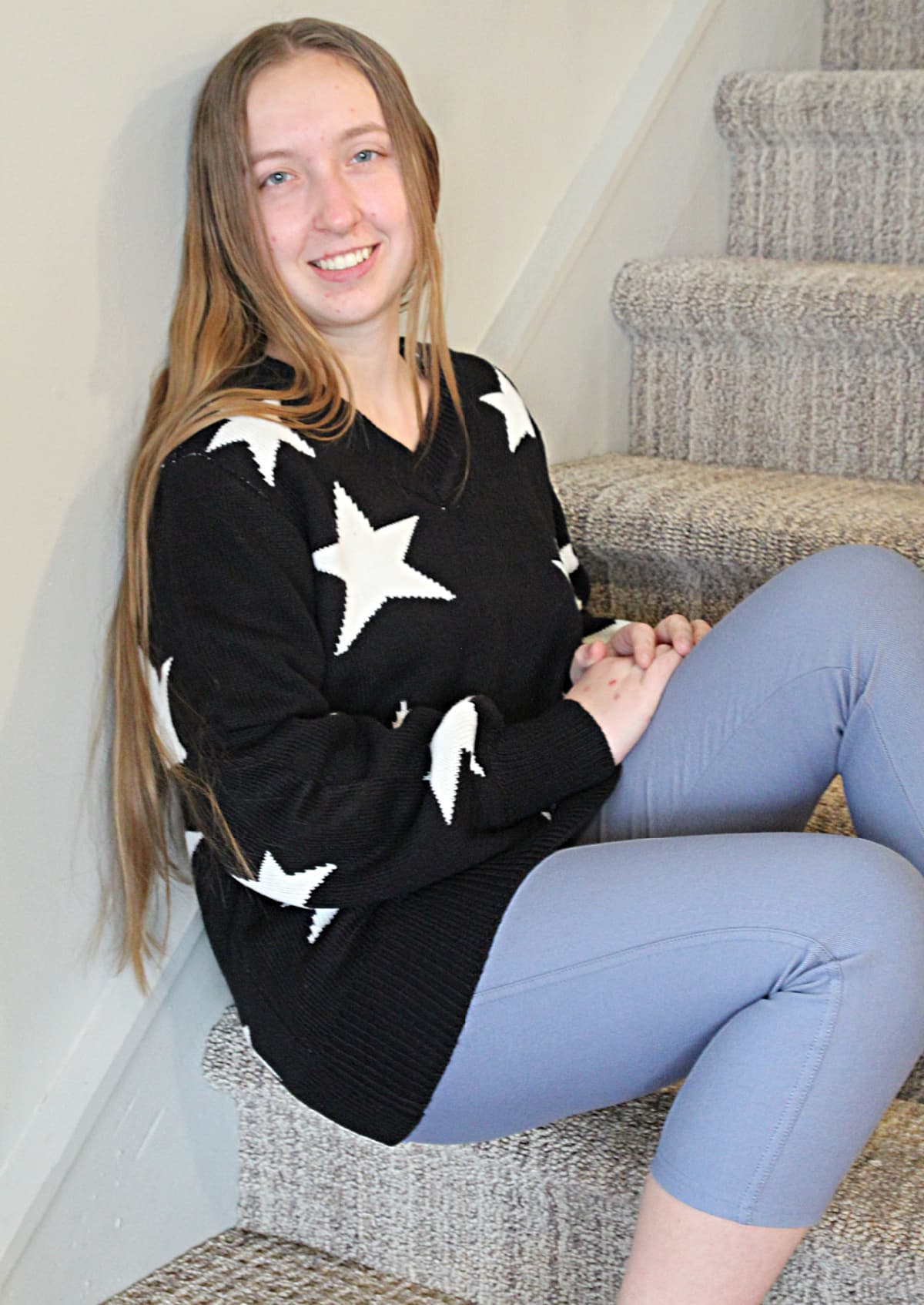 girl in star sweater sitting on steps - Nadine West Fashion Subscription Review