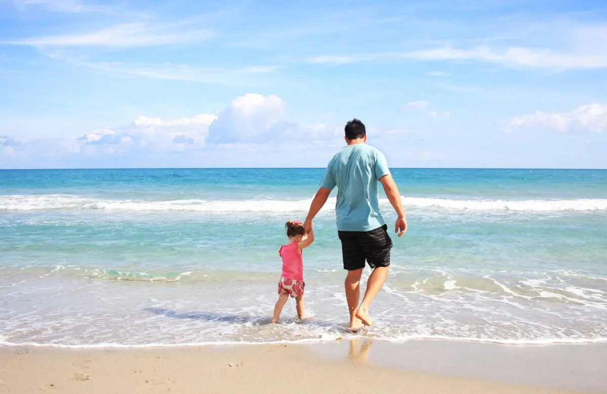 Dad and child at beach - Ultimate HUGE List Of Beach Day Must Haves That You'll Go Crazy For