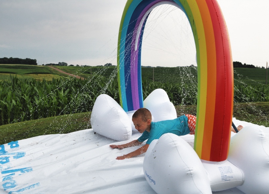 25 Affordable Or Free Kids Activities For Your Backyard - Giant Homemade Slip n' Slide with Rainbow Sprinkler (affordable backyard fun)