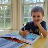 preschool boy doing homeschool work at table