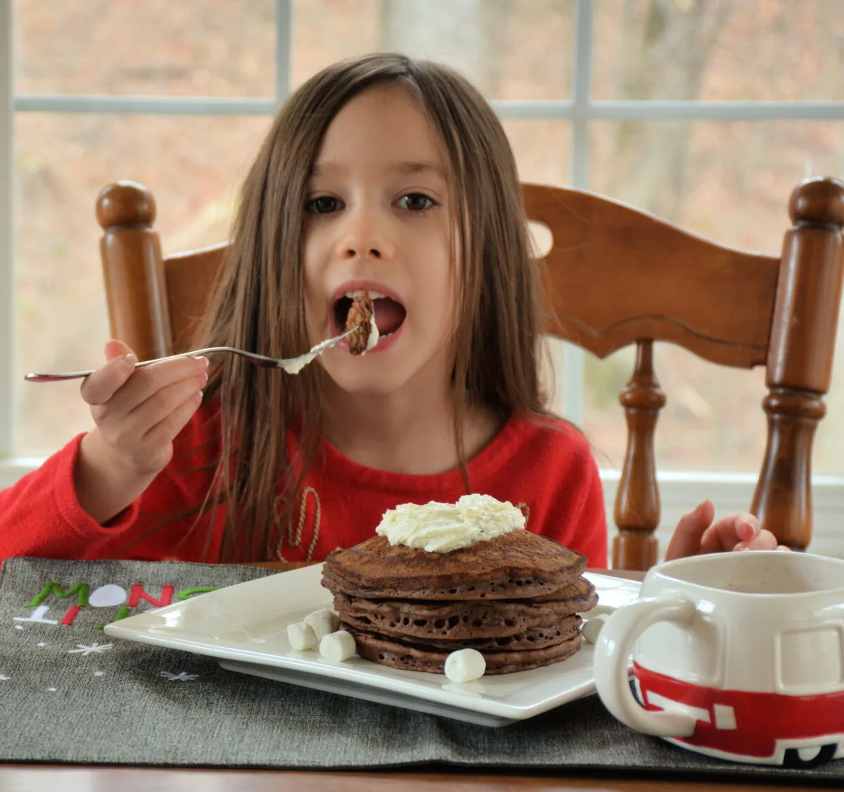 little girl eating hot chocolate pancakes