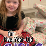 five year old girl with presents and a text overlay that says "Christmas Gifts for Five Year Old Girls"