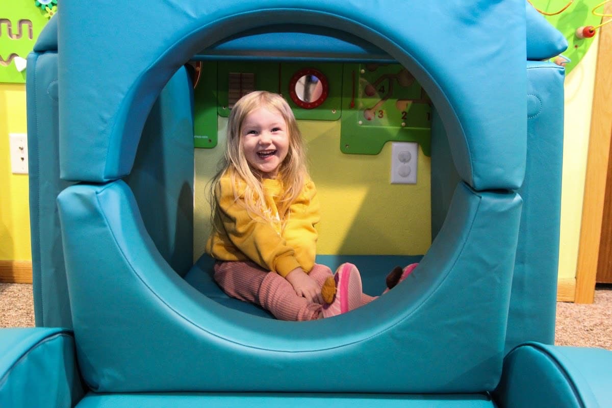 Girl Smiling In Fort Cushions - Adding Wow Factors To Your Play Space
