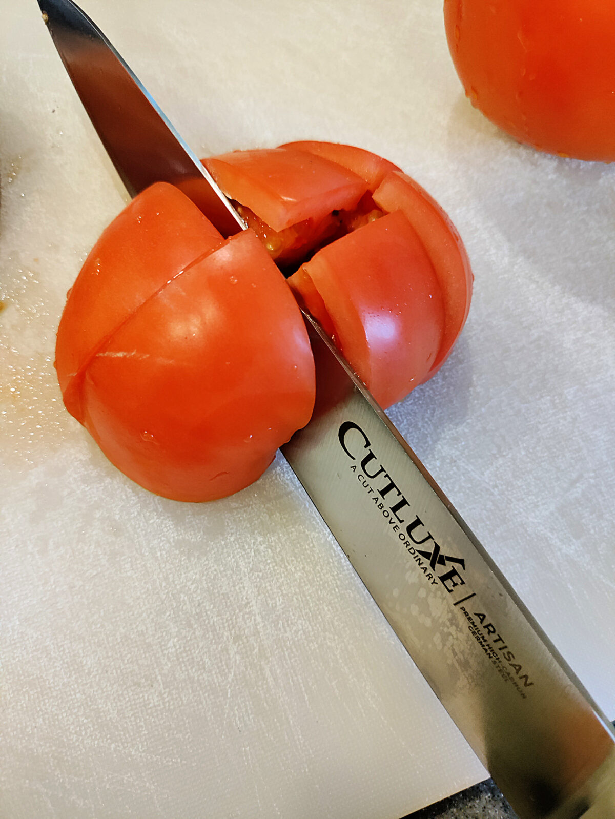 Cutluxe knife cutting a tomato