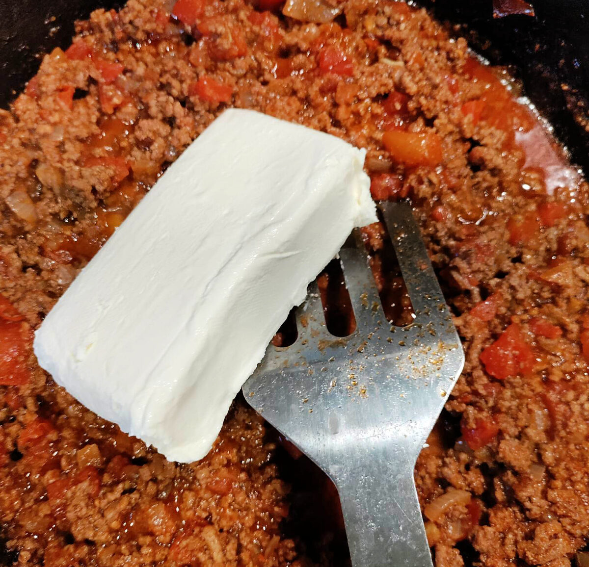 Mixing cream cheese in with the ground beef, Rotel, and onions for the Mexican Lasagna recipe