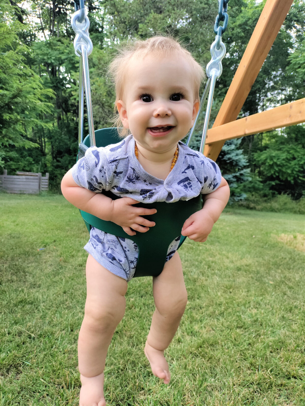 baby swinging in a backyard adventures swing
